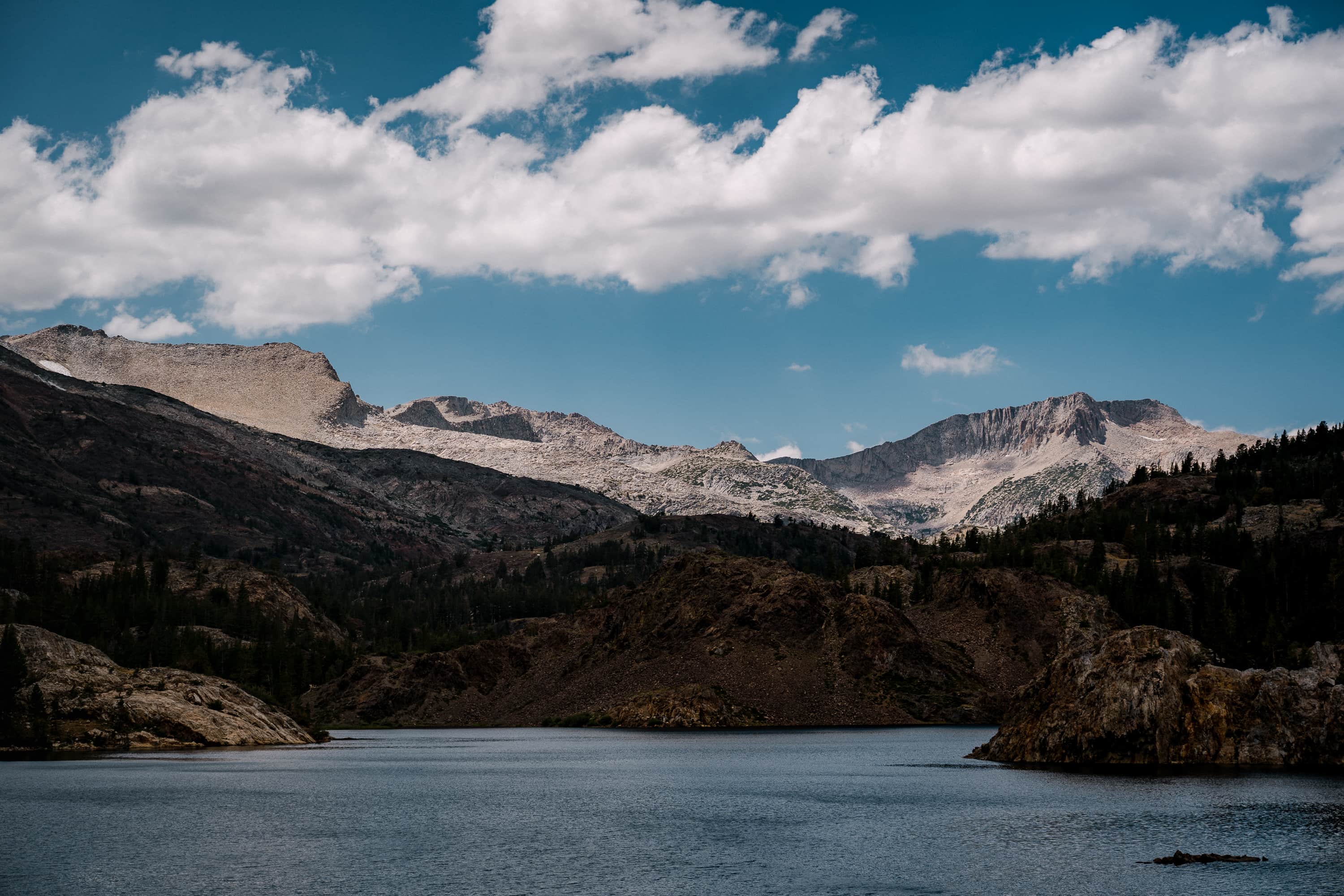 An alpine lake in the Sierras near with mountains in the background.